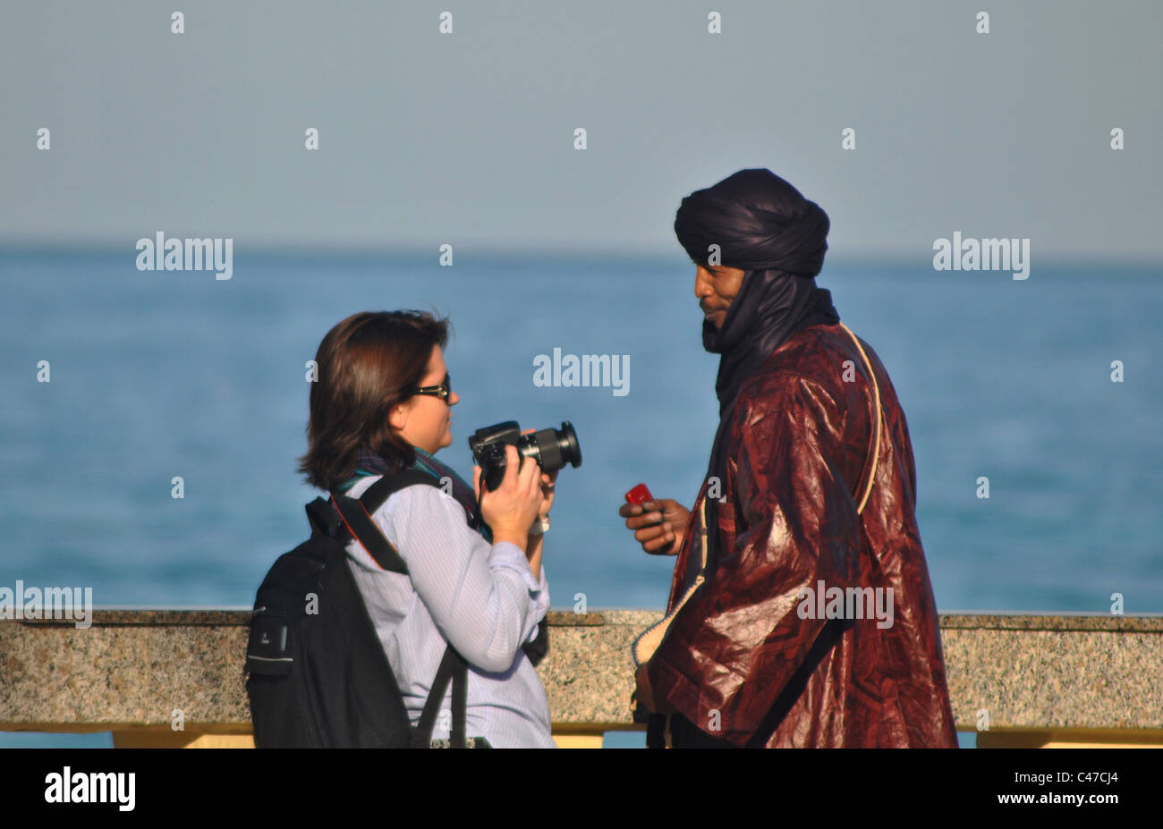 Woman taking a photo of a Tunisian man in Sousse, Tunisia Stock Photo