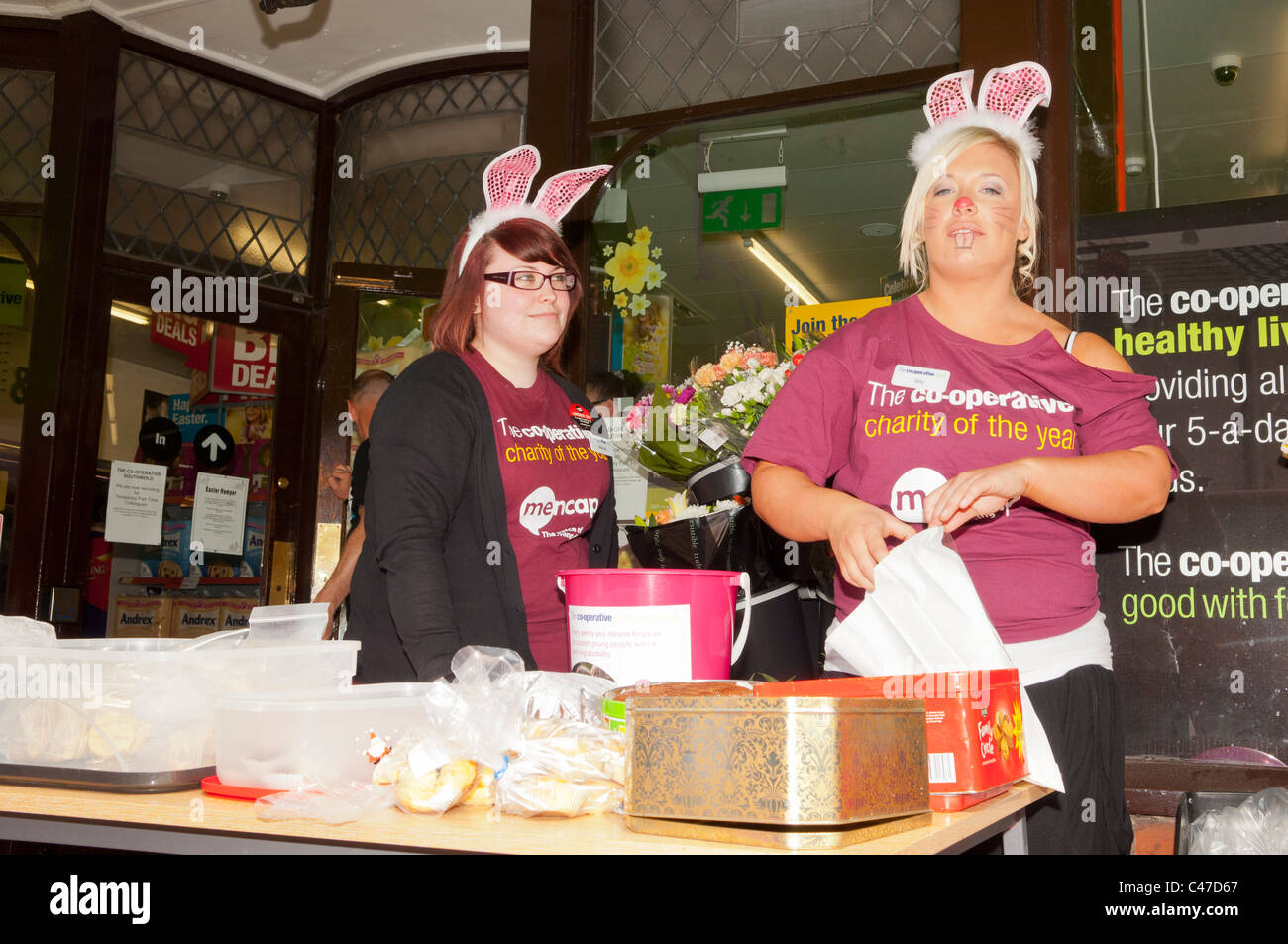 Cooperative staff selling cakes for charity outside their store in the