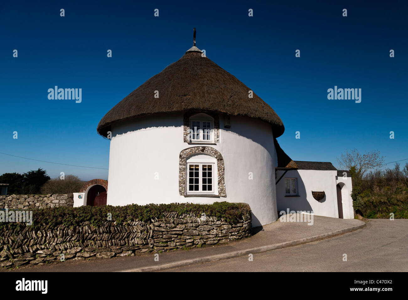 Thatched Cornish Round House Cottage And Blue Sky Stock Photo