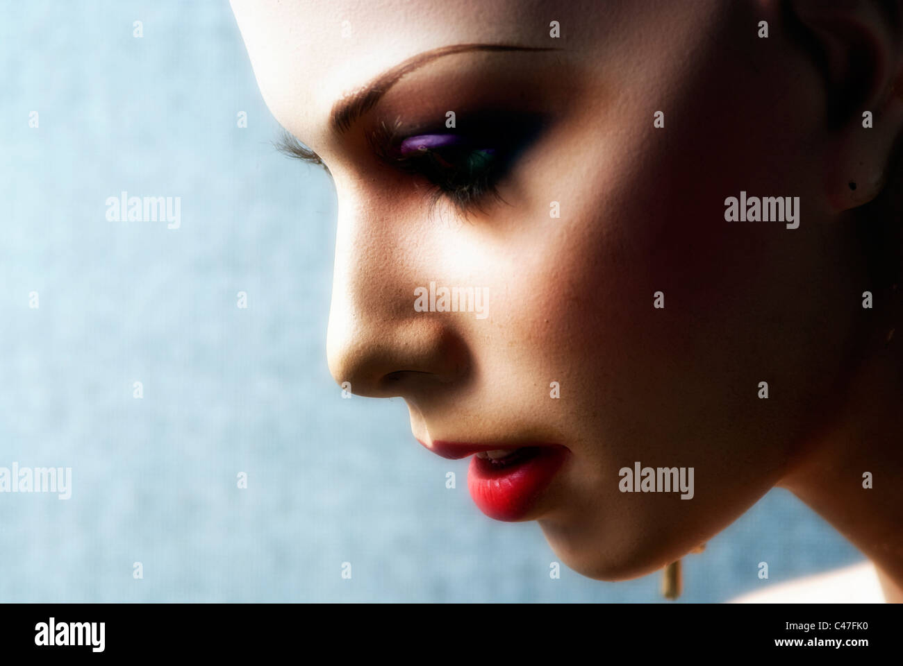 Close-up photo of a mannequin’s face in profile, wearing make-up Stock