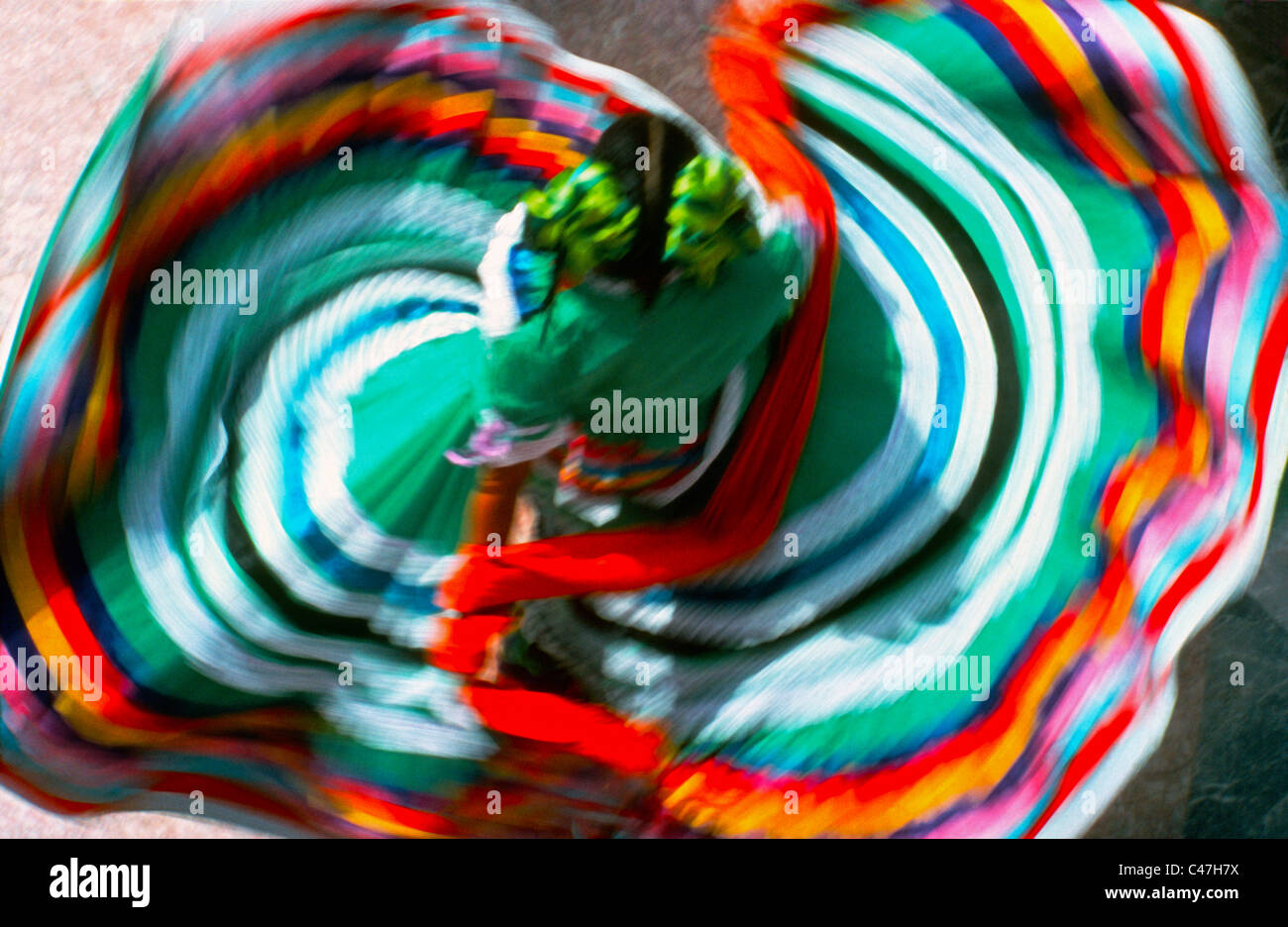 An overhead view shows off the colorful traditional dress of a twirling folkloric dancer who often entertains tourists in Mexico, North America. Stock Photo