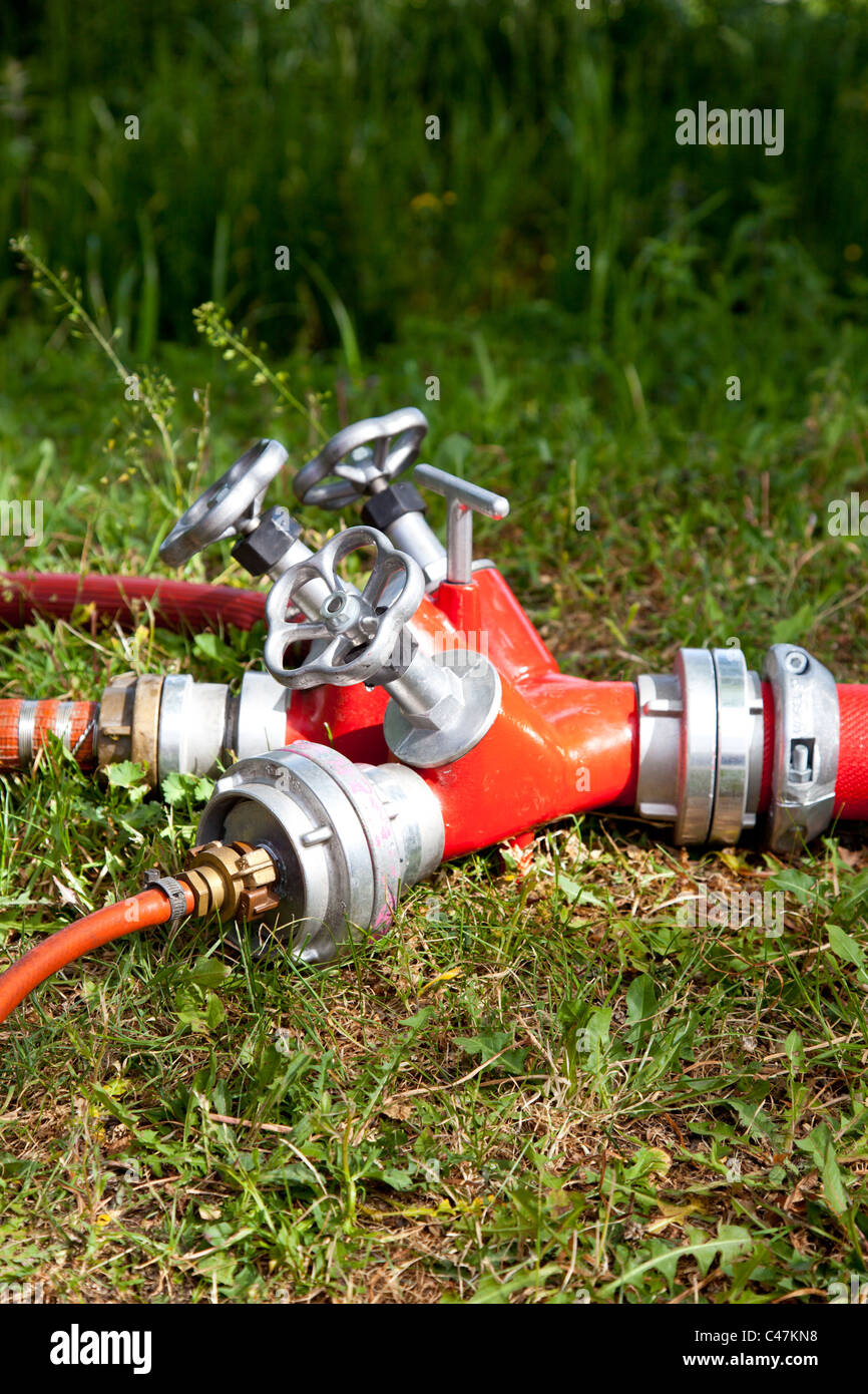 fire hose connection in grass Stock Photo
