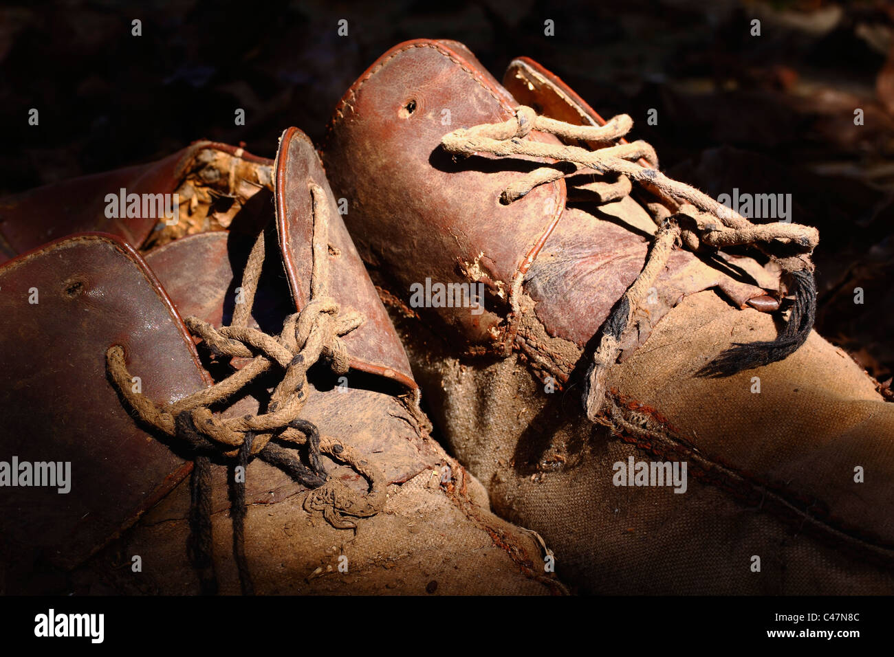 A pair of old worn out brown leather and canvas men's shoes. Copy space. Stock Photo