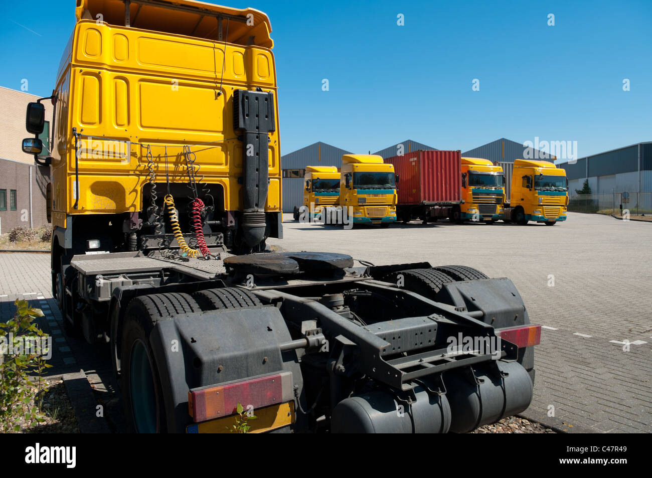 yellow trucks parked on an industrial area Stock Photo
