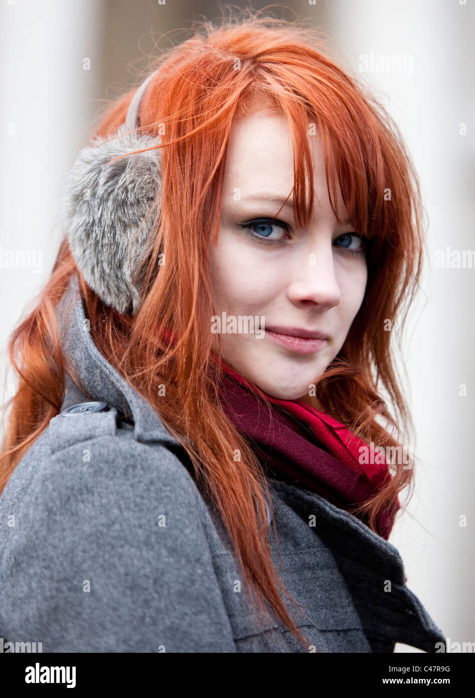 Headshot portrait of a ginger haired teenager wearing ear muffs in a cold winter, London, England, UK, GB. Stock Photo