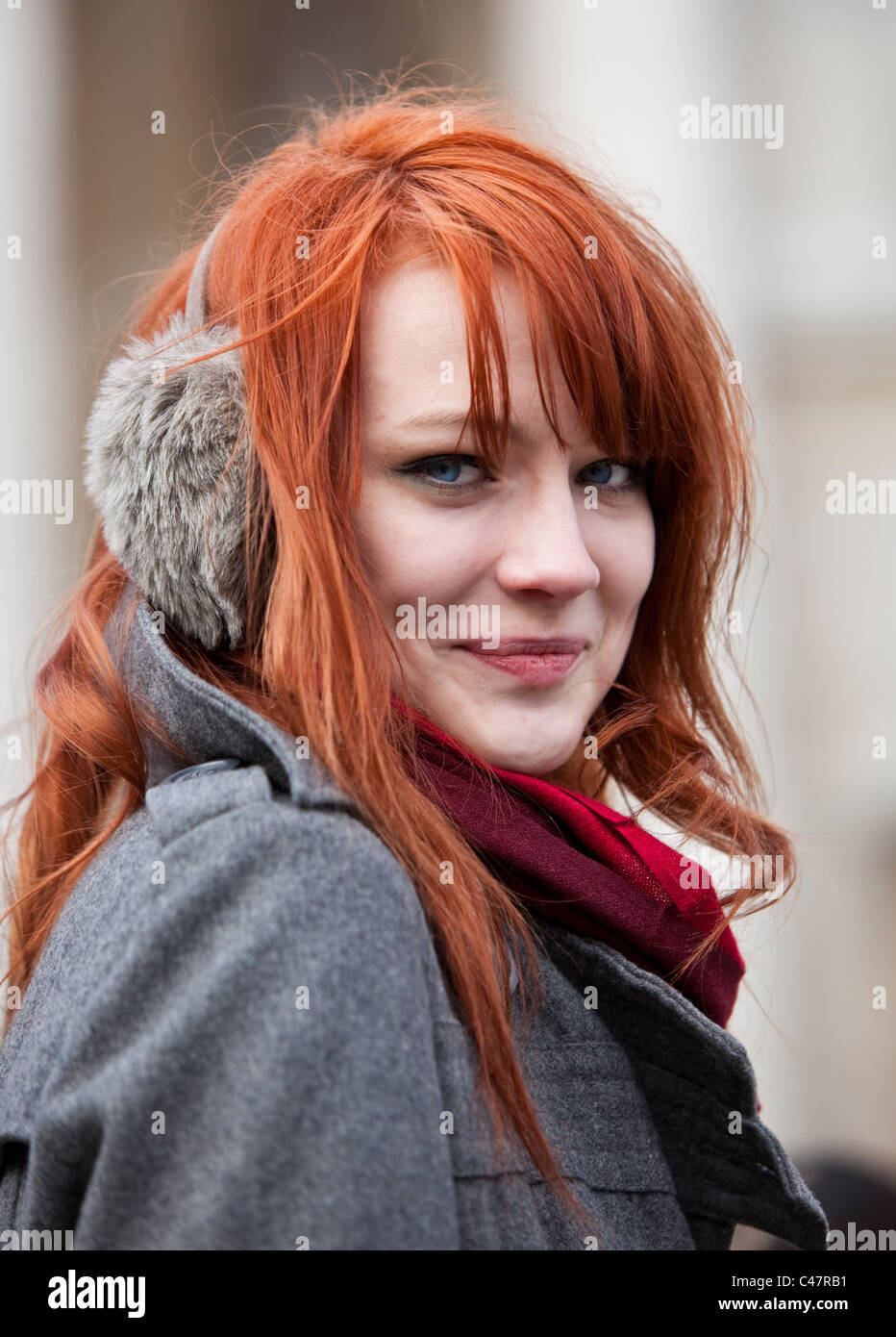 Headshot portrait of a ginger haired teenager wearing earmuffs in
