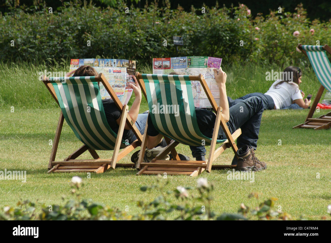 Tourists in Regents Park deckchairs Stock Photo