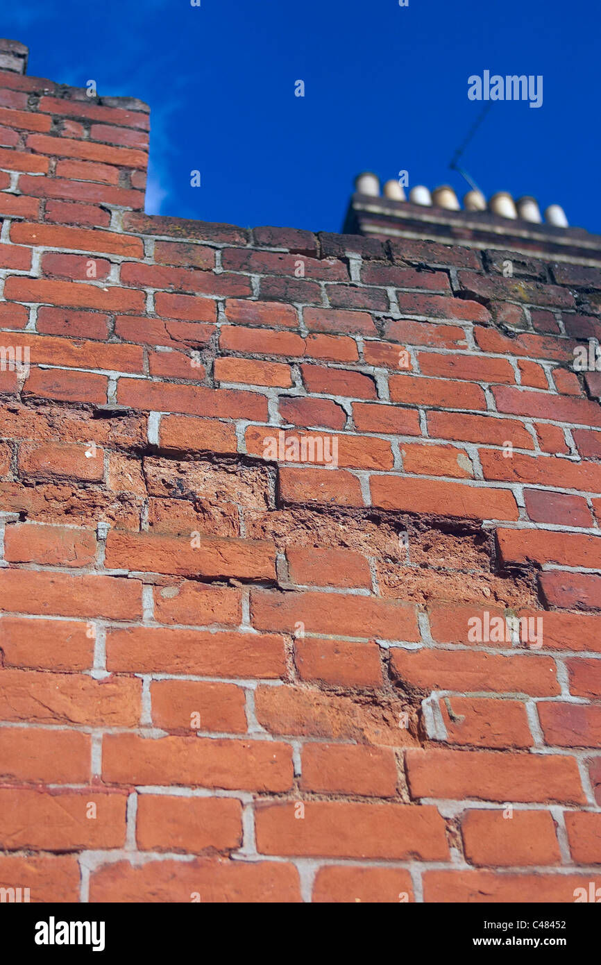 Serious decay of mortar joints and crumbling brick faces caused by