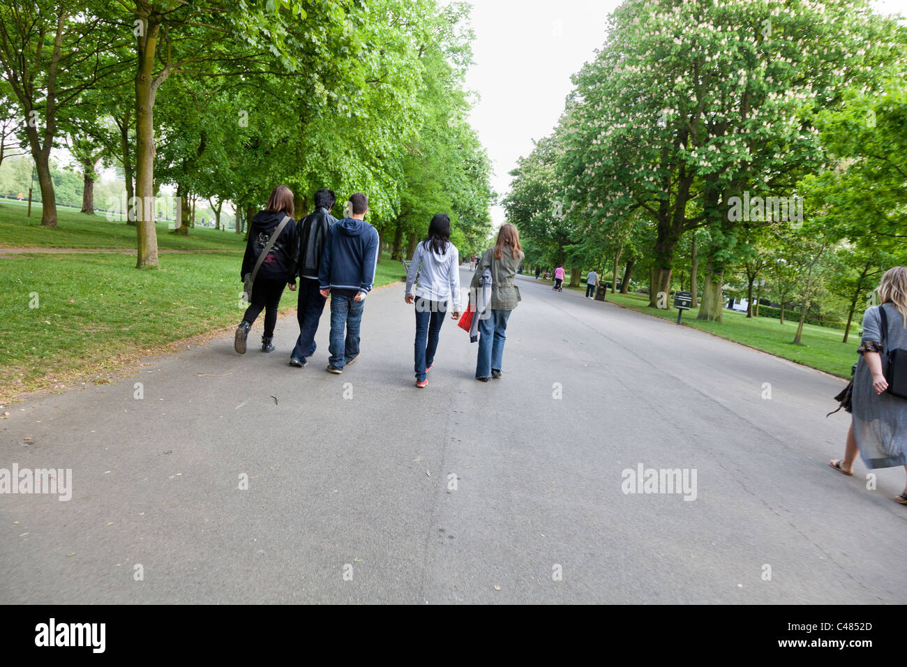 Young people walk along a footpath in Regent's Park, London Stock Photo ...