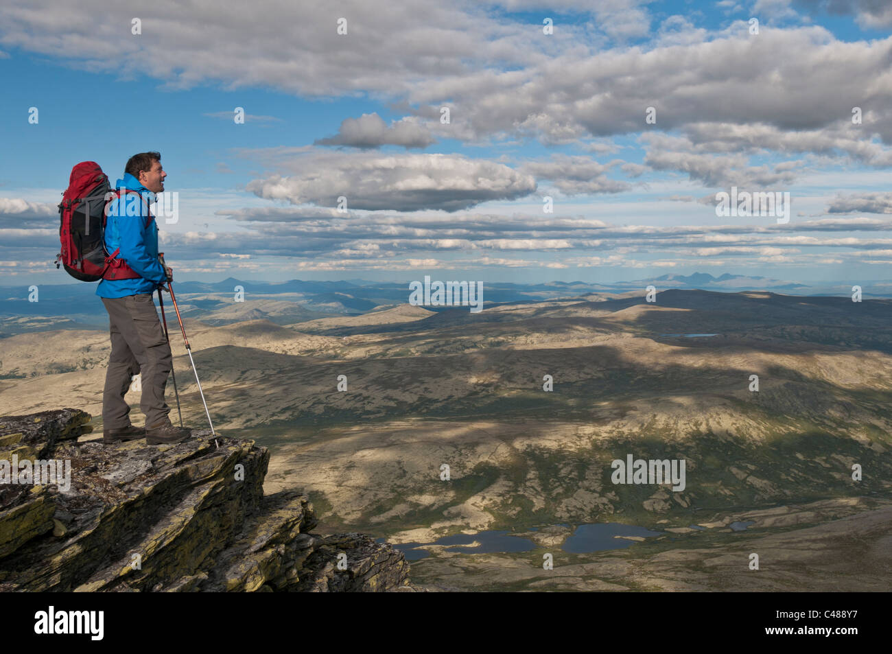 Wanderer auf einem Gipfel im Alvdal Vestfjell, in der Ferne der Berg Rendalssoelen, Rendalen, Hedmark, Norwegen Stock Photo