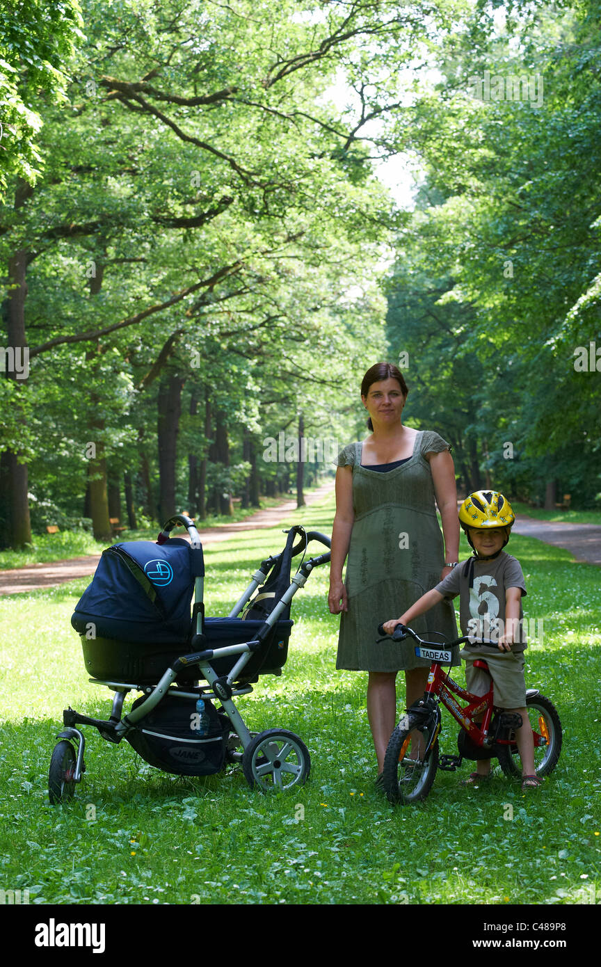 Child blond boy 4 years old riding bicycle with safety helmet in park
