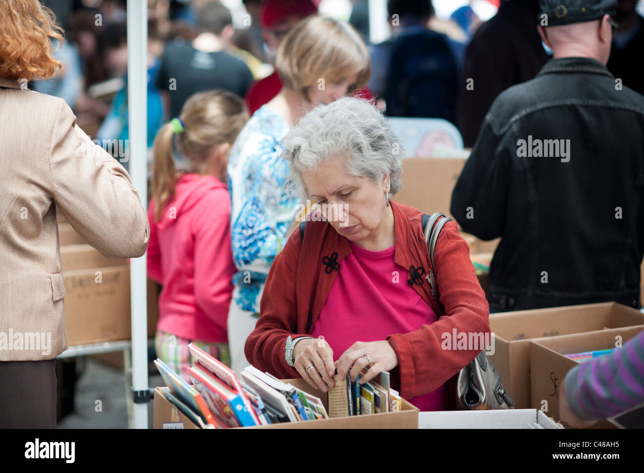 Shoppers search for bargains amidst the chaos of the Housing Works street fair in the New York neighborhood of Soho Stock Photo