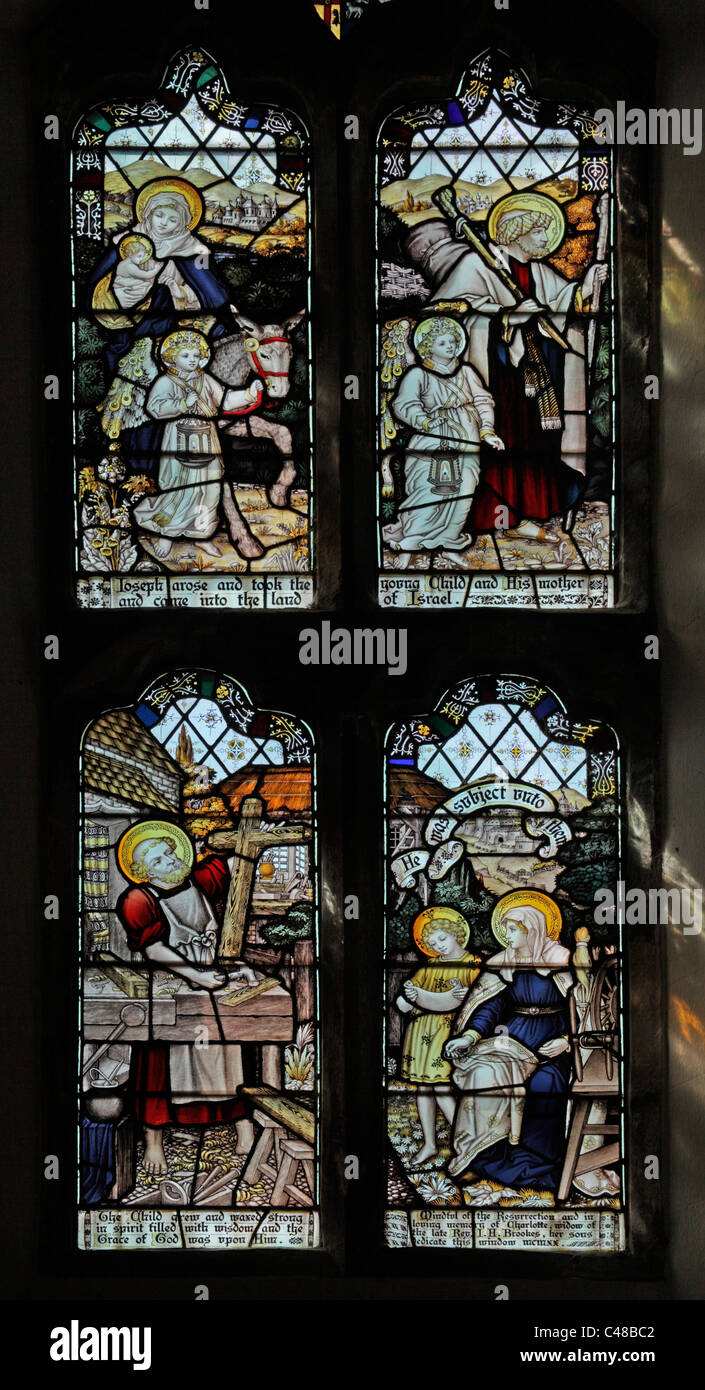 A stained glass window by The Kempe Studios depicting The Holy Family Return from Egypt and the Carpenter's Shop Stock Photo