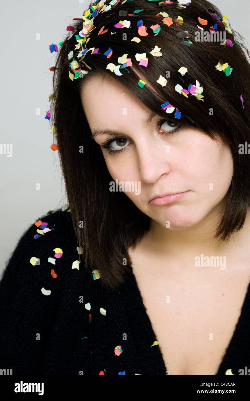 A sad-looking woman with confetti in her hair Stock Photo