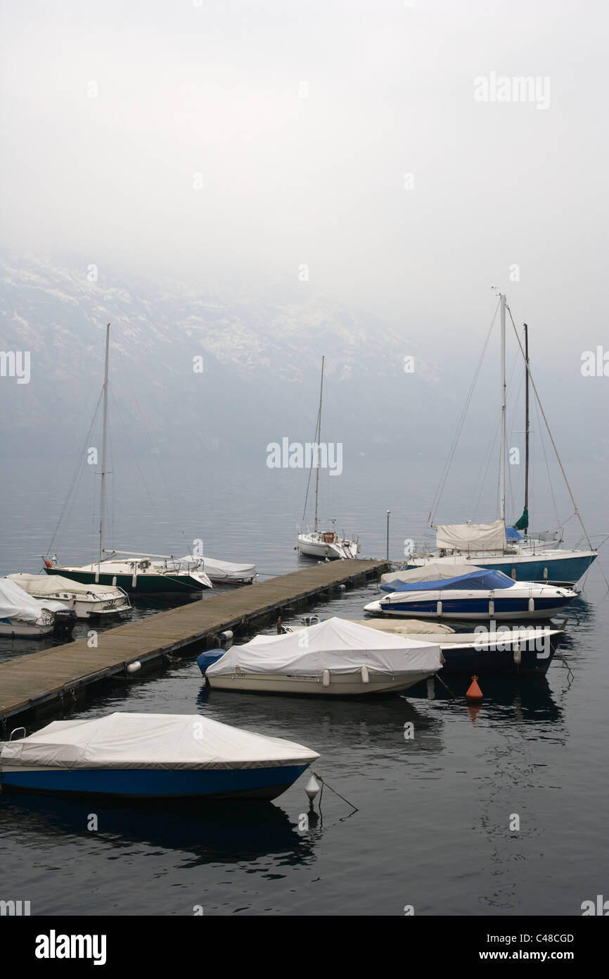 Moorage with boats against Lake Como at Tremezzo. Lombardy. Italy. Winter. Stock Photo