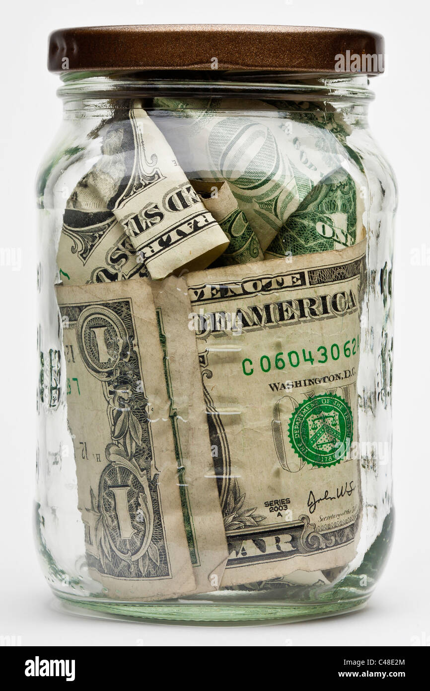 tips jar containing us currency in coins and paper dollar bills Stock