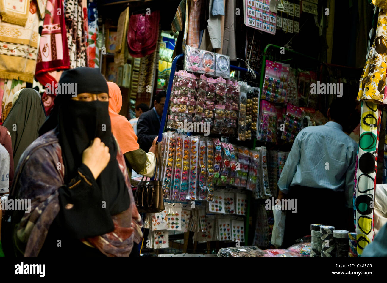 Market scenes in Cairo, Egypt. A veiled woman walking through a narrow market street. Stock Photo