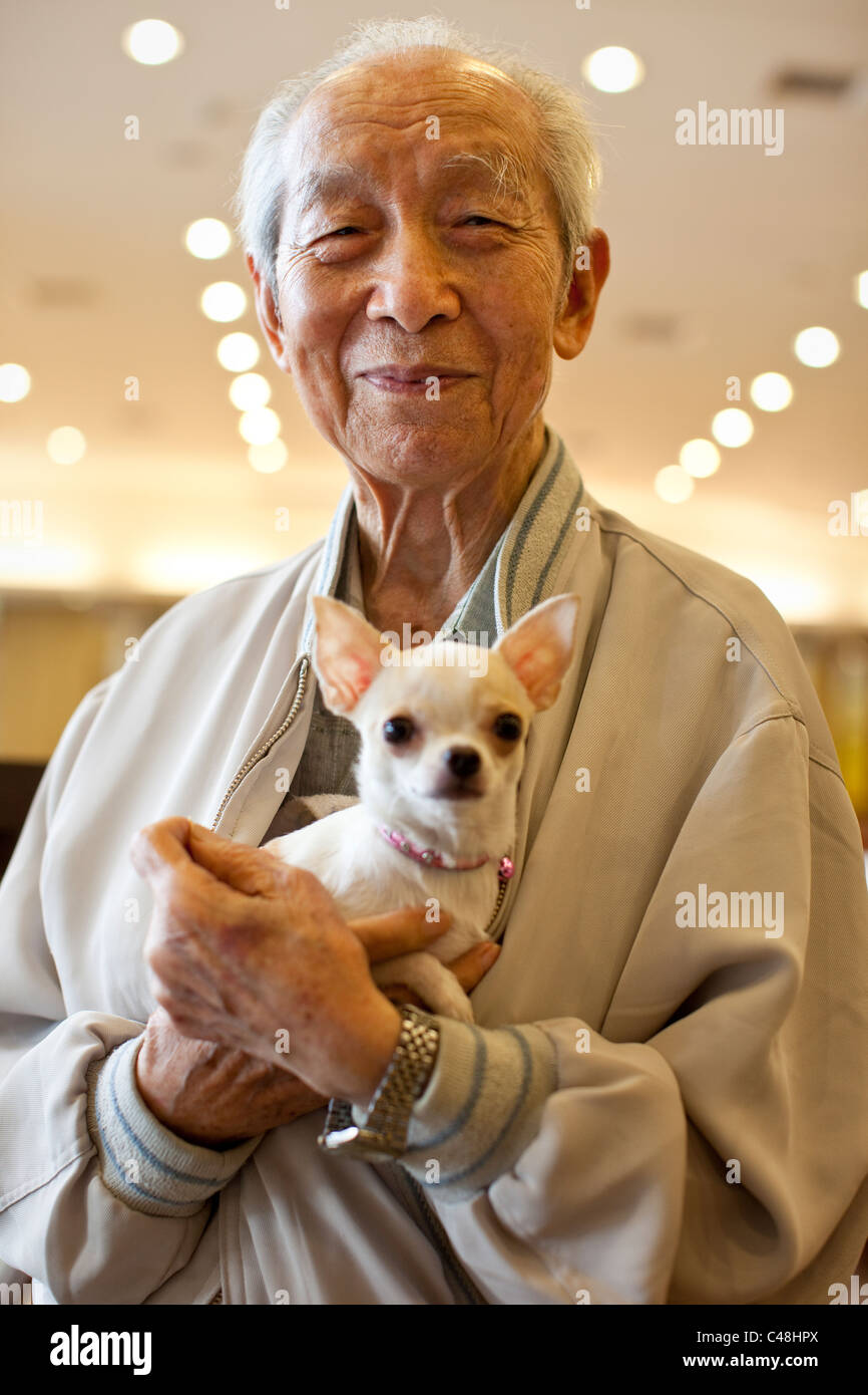 A Taiwanese man with his little dog, Puli Restaurant, Taiwan, October 21, 2010. Stock Photo
