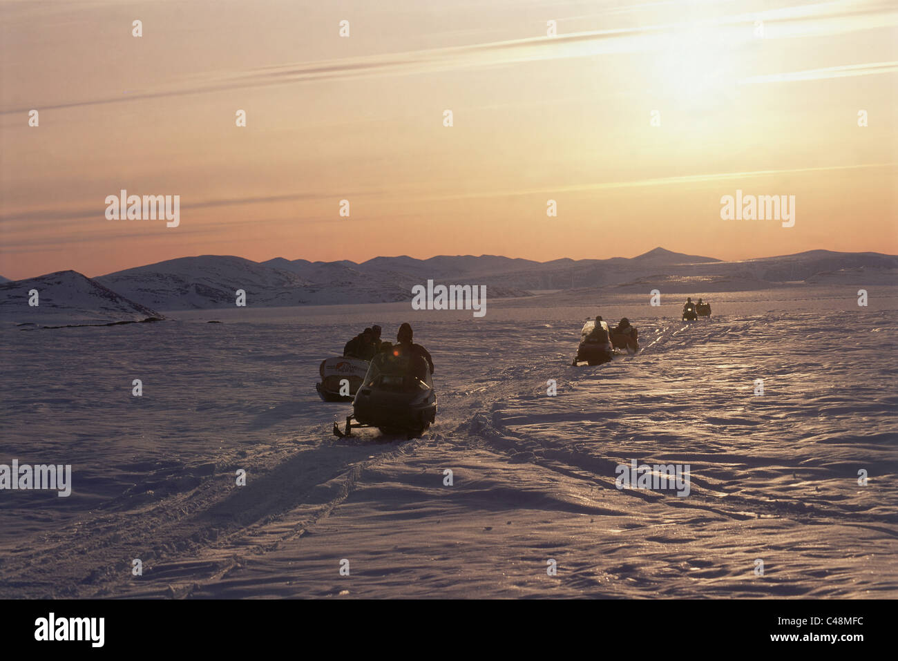 Image of a convoy of motorbikes on the ice plains of Baffin Canada Stock Photo