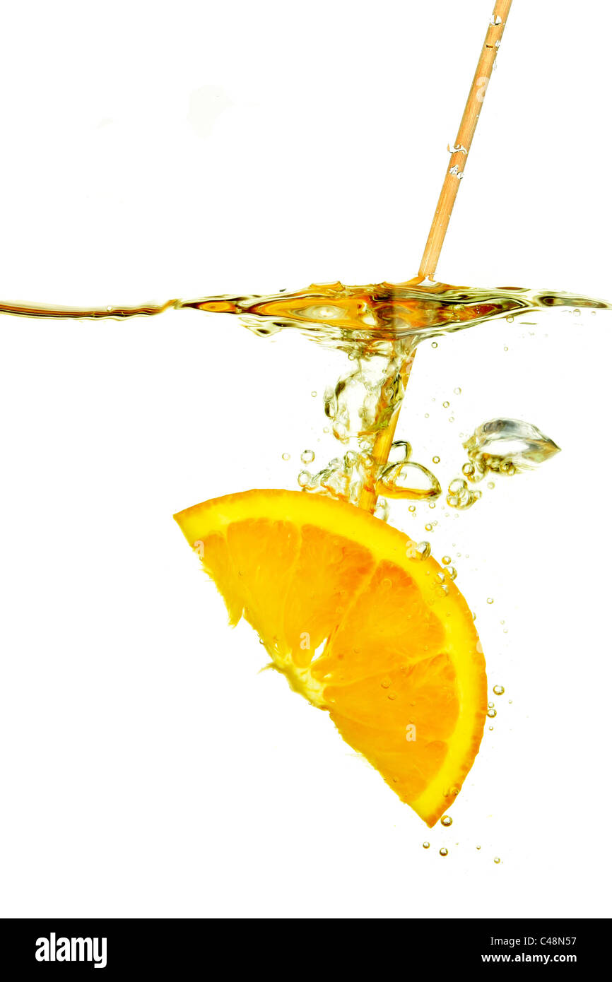 Slice of orange on a cocktail stick in water with bubbles and surface reflections Stock Photo