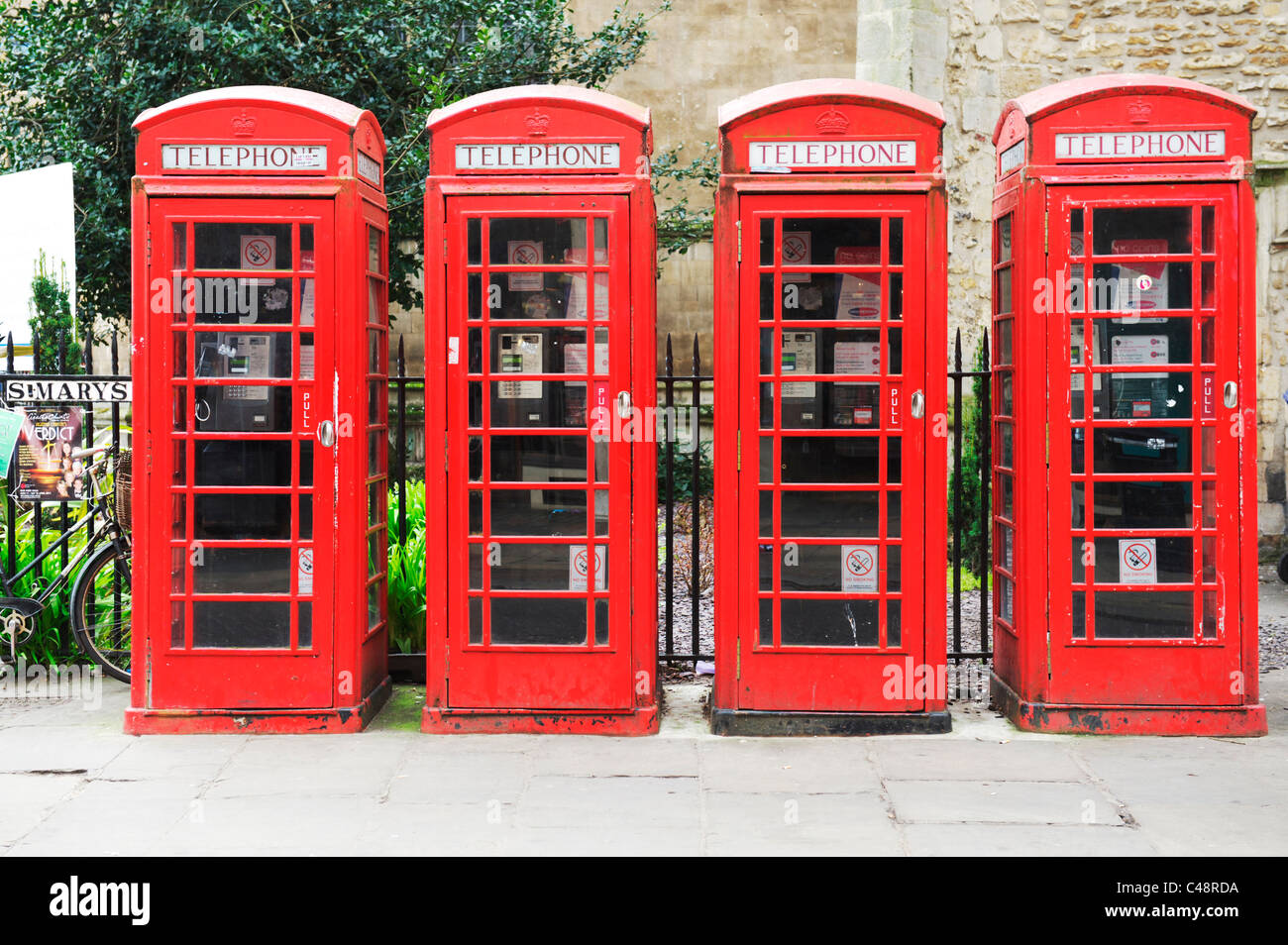 Four red British telecom telephone boxes in a street in the university town of Cambridge in England Stock Photo
