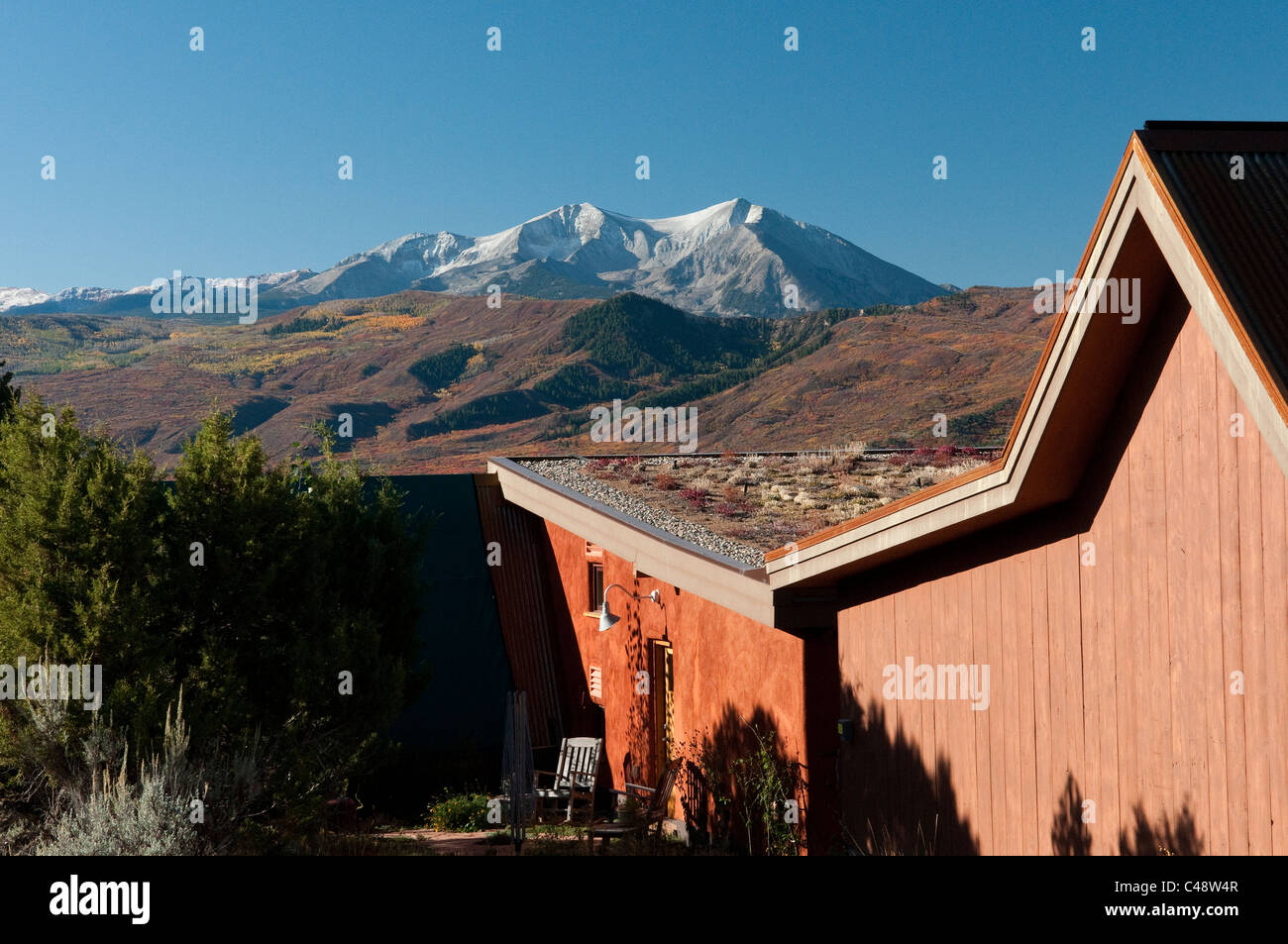 View of Mt. Sopris in the fall beyond a sustainable country home with a living roof in the Roaring Fork Valley, CO. Stock Photo