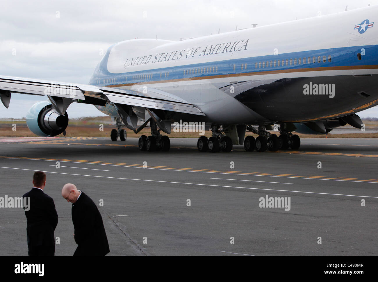 Secret Service agents turn away from the backwash as Air Force One taxis on the tarmac Stock Photo