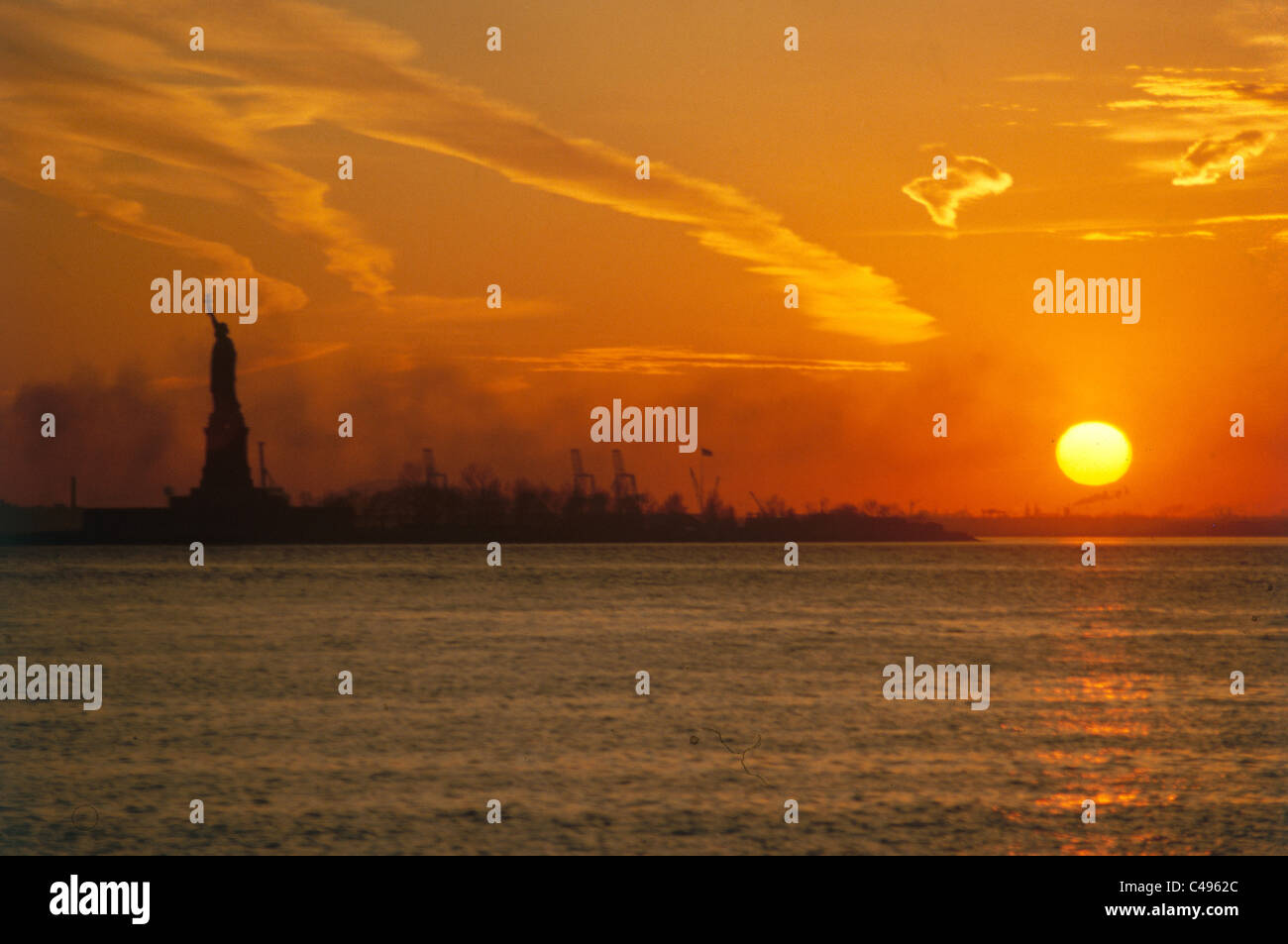 Photograph of the sunset over the Statue of Liberty in New York City Stock Photo