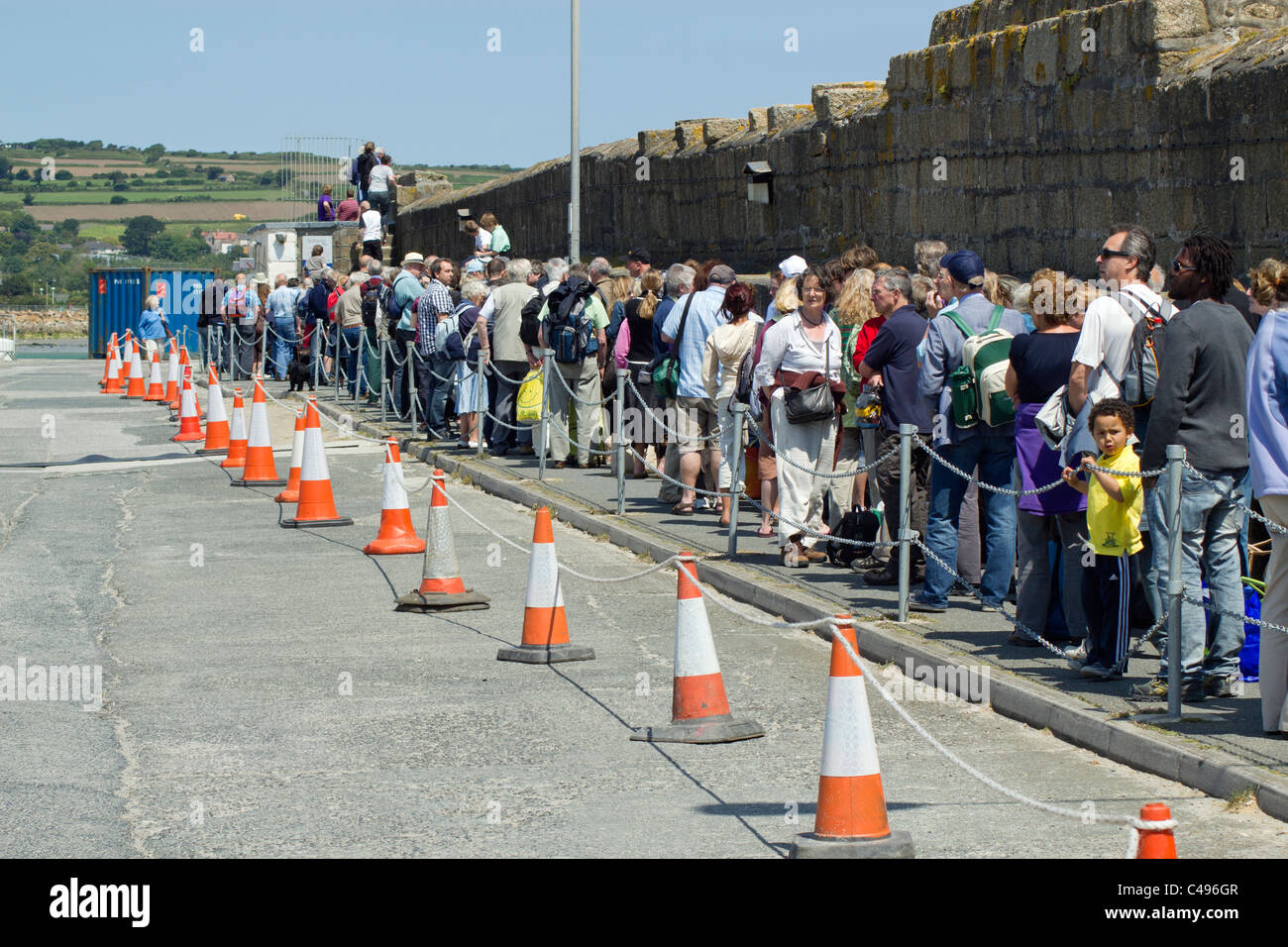 A long queue of people on Penzance pier waiting to board the Scillonian III ferry to the Isles of Scilly. Stock Photo