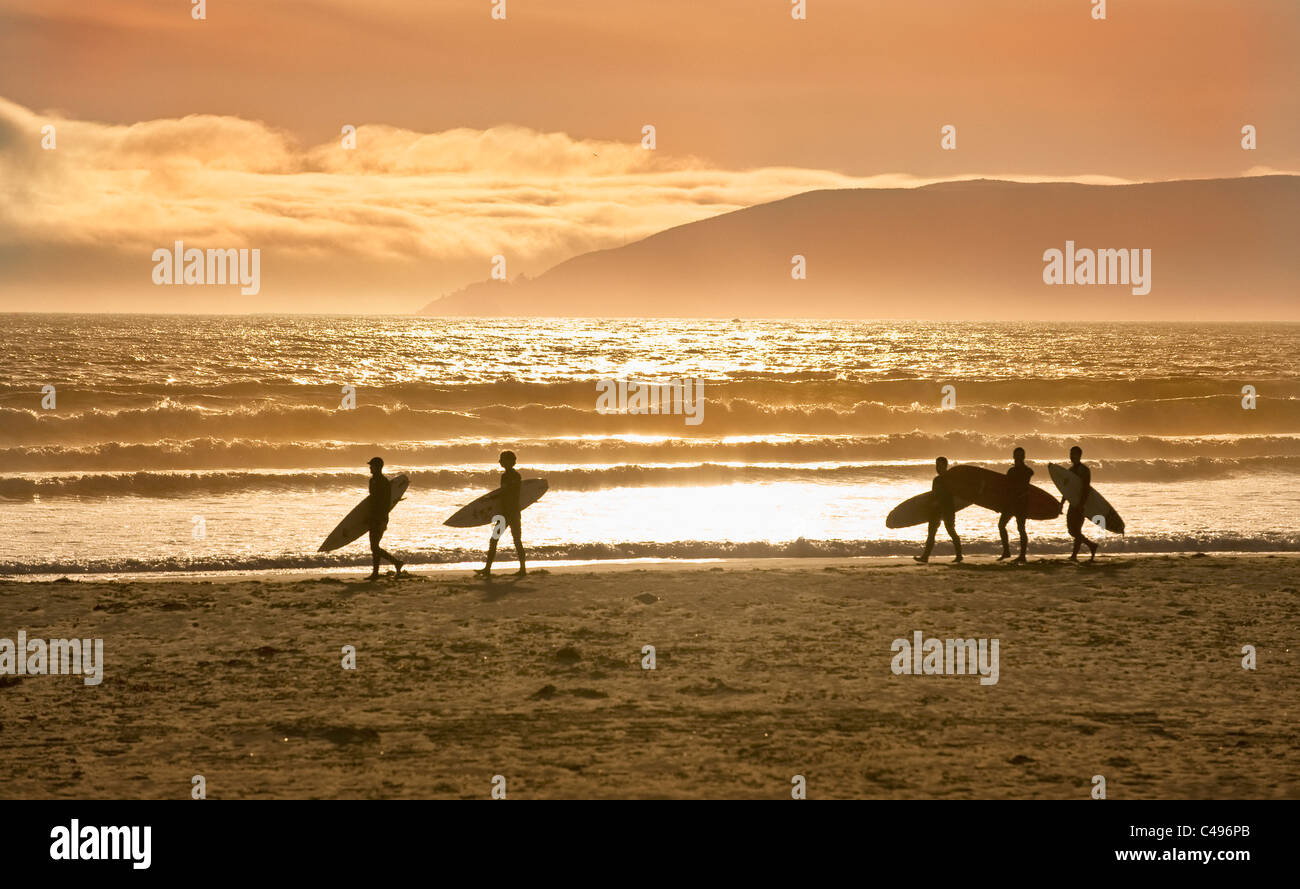 Five surfers walking with surfboards on beach, Pismo Beach, California, USA Stock Photo