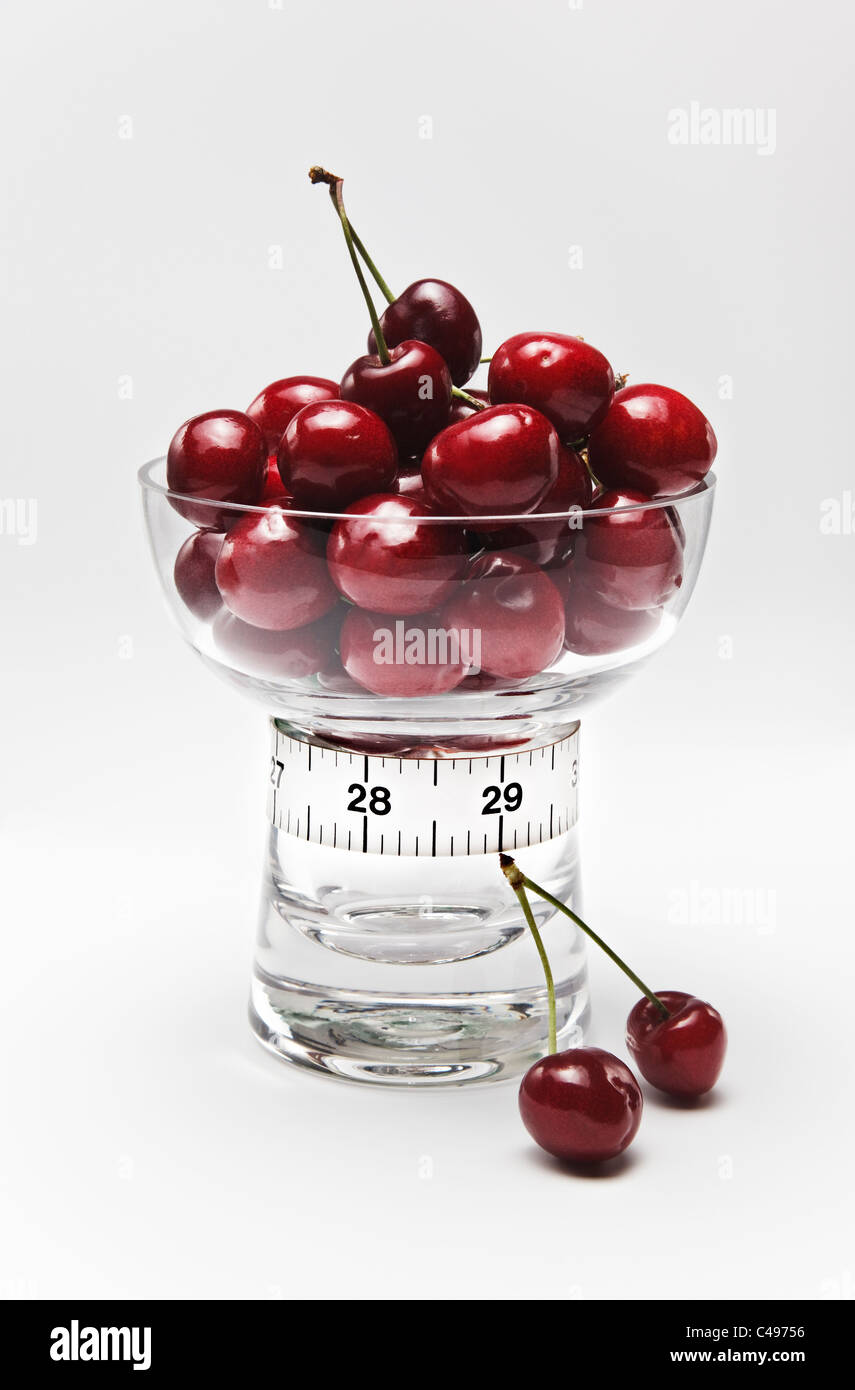 Cherries in Glass Dish and Tape Measure in Inches Stock Photo