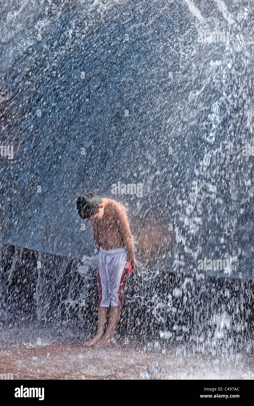 Young boy playing in steel water fountain, Seattle Center, Seattle, Washington, USA Stock Photo