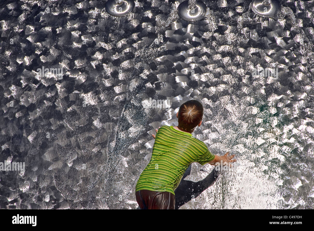 Young boy playing in steel water fountain, Seattle Center, Seattle, Washington, USA Stock Photo