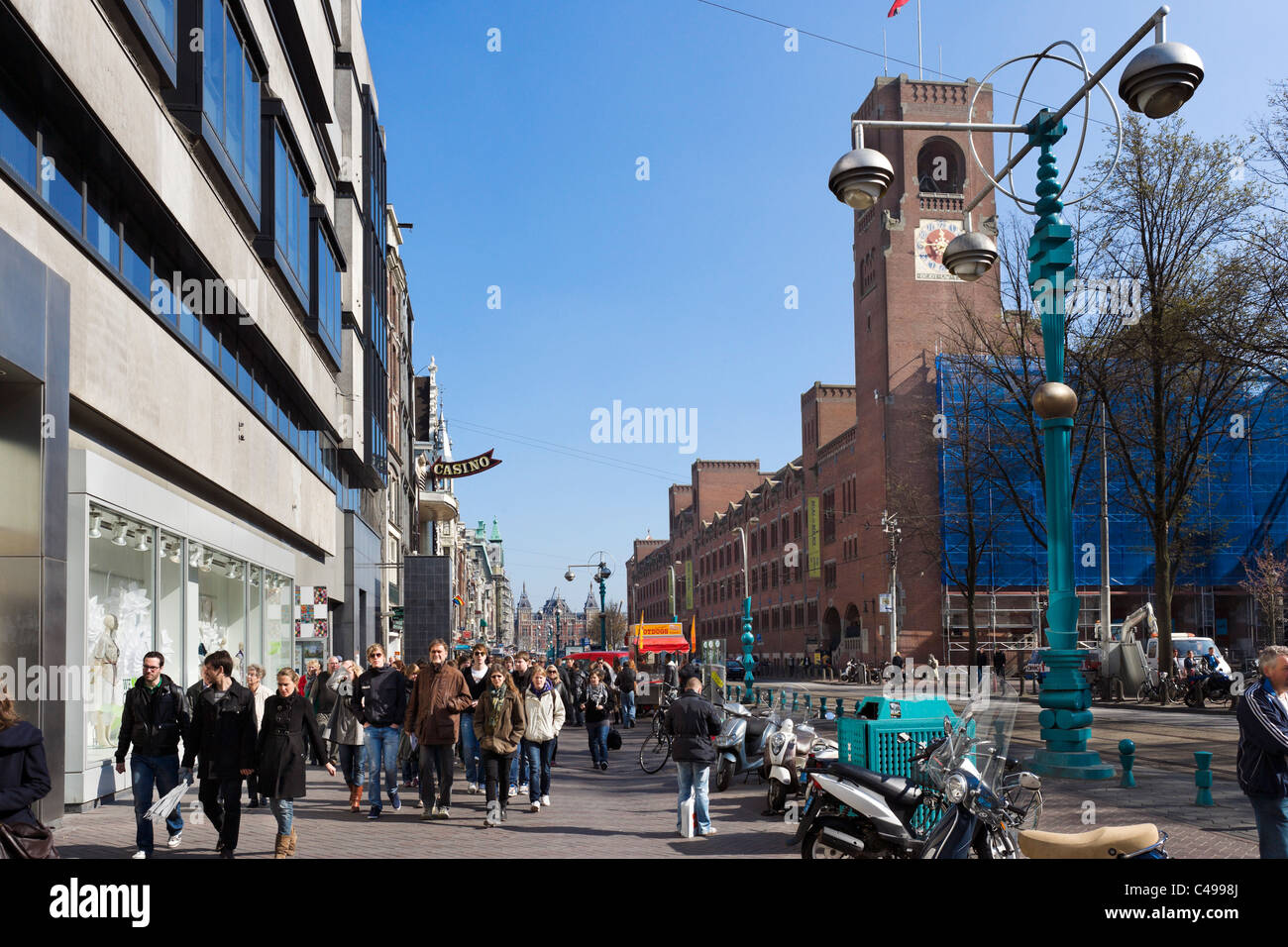 Shops on Damrak with Beurs van Berlage (the old Stock Exchange) on the right, Amsterdam, Netherlands Stock Photo
