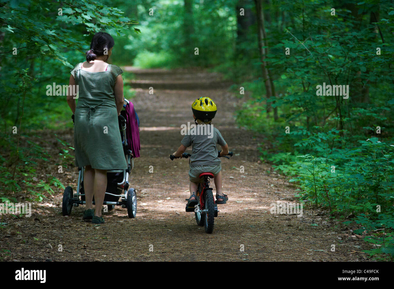 Child boy 4 years old riding bicycle with safety helmet in park and