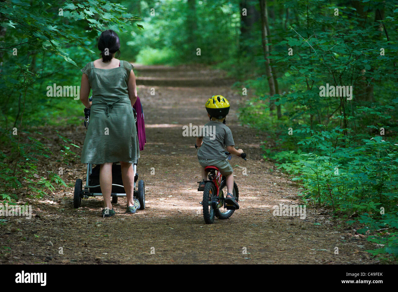 Child boy 4 years old riding bicycle with safety helmet in park and