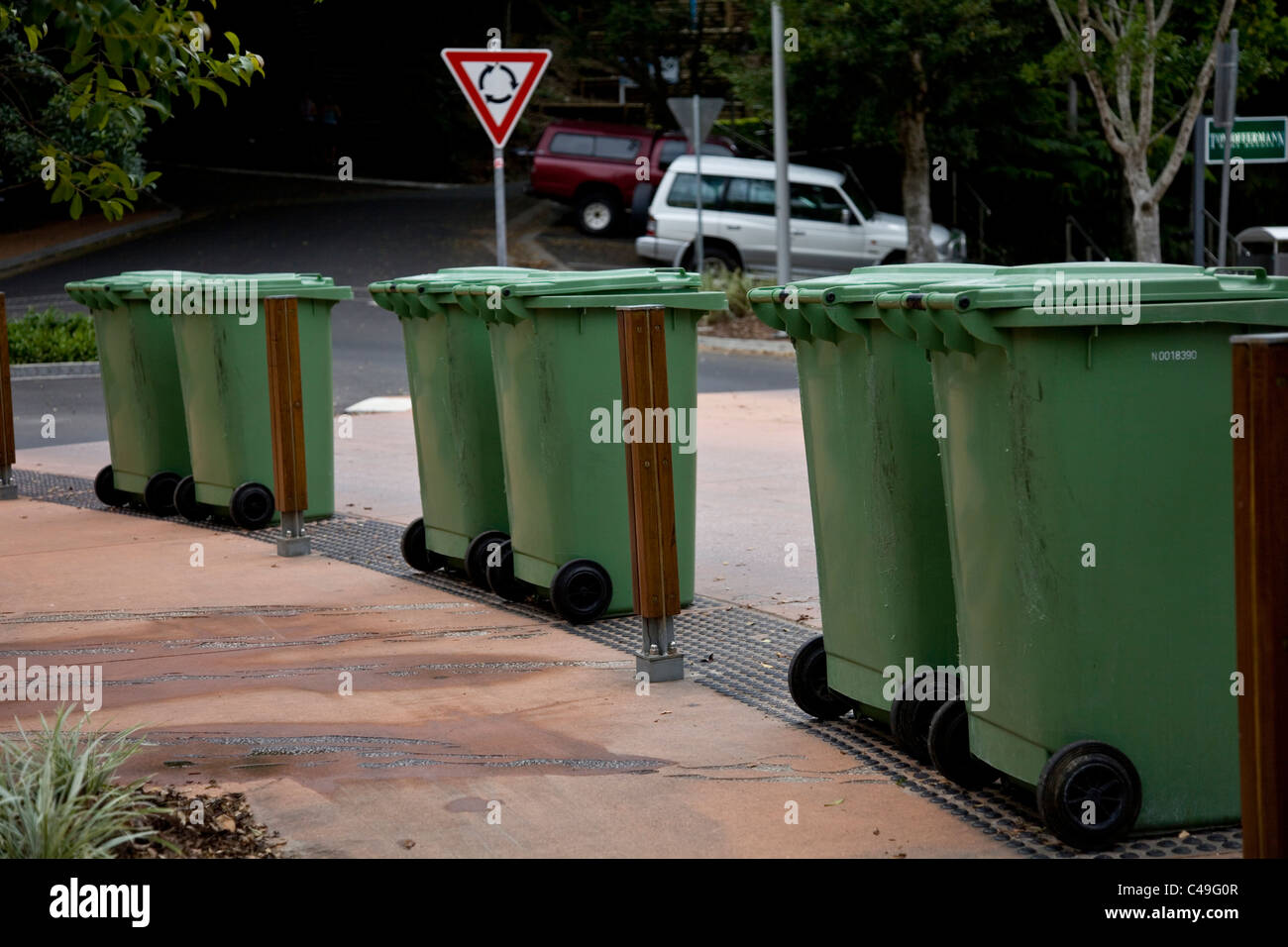 Green recycling bins awaiting collection at the roadside. Stock Photo