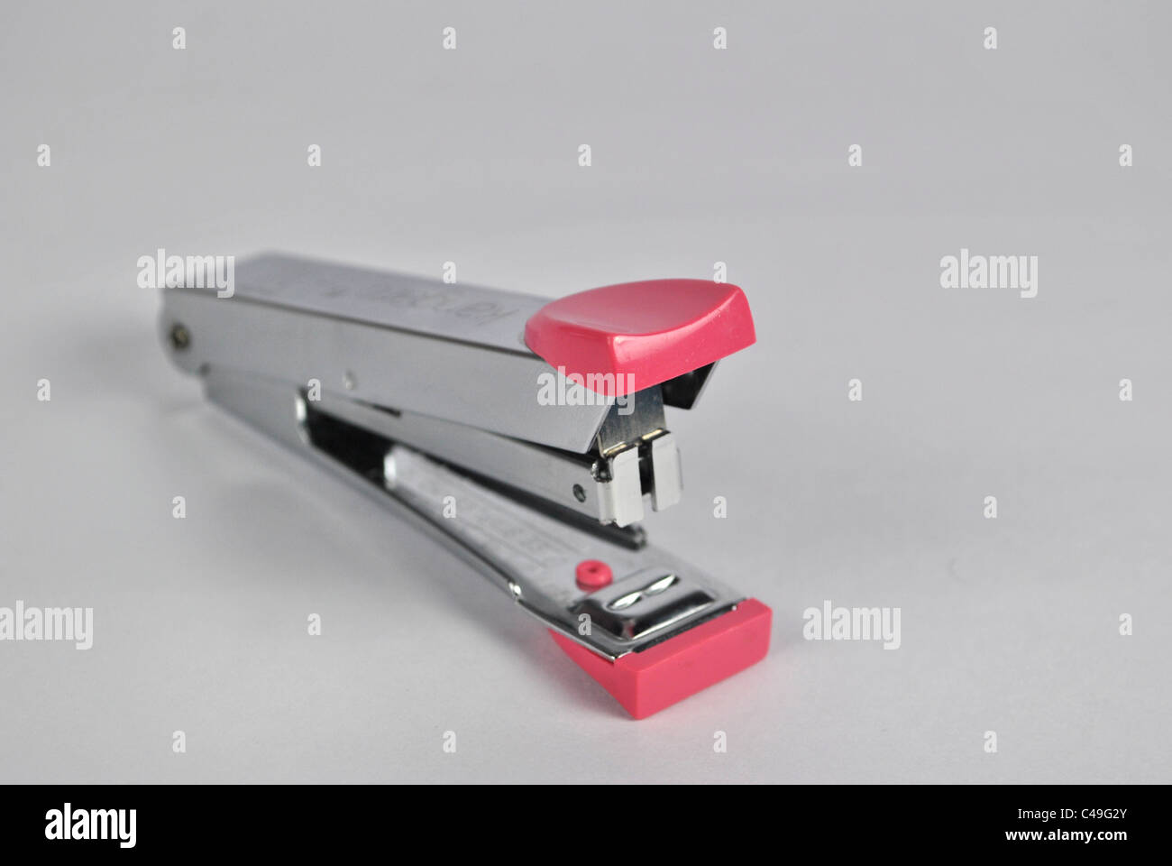 stapler office stationary pin adjoining grouping cut out cut-out silo white background metal plastic fiber shiny silver Stock Photo