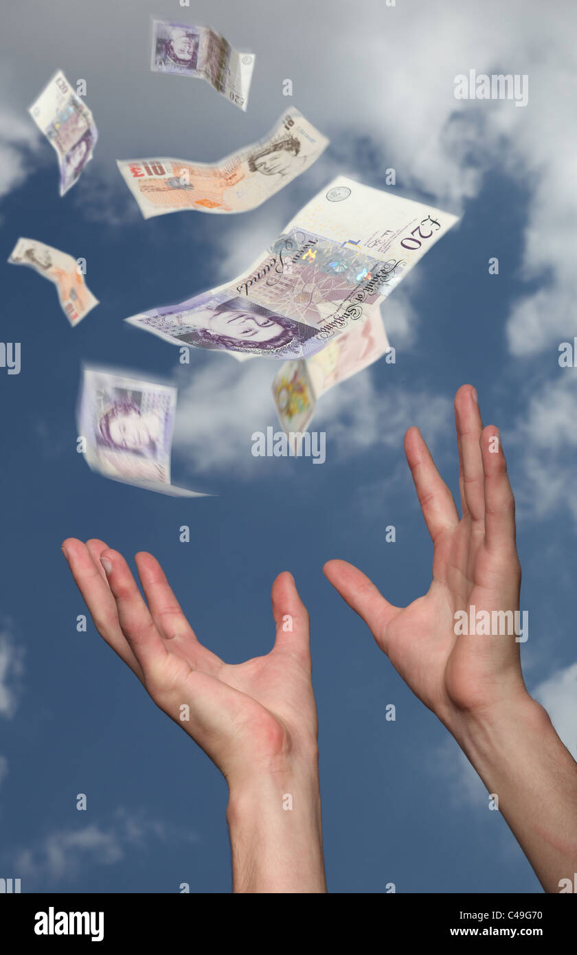 British pounds falling from the sky, man's hands reach up to try to catch the money. Stock Photo