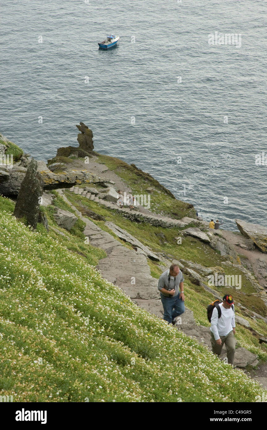 Photograph of two men walking up a cliff in Ireland Stock Photo