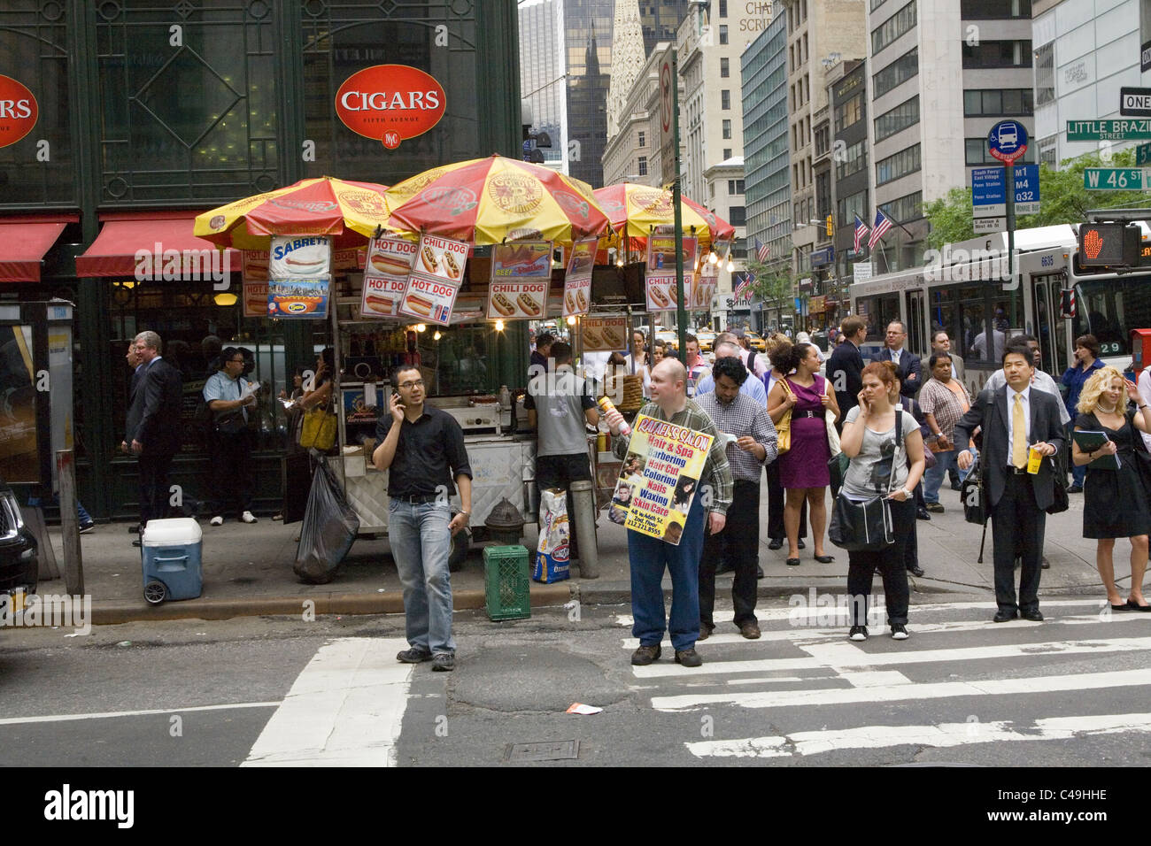 Vendors and pedestrians clogs the street corners in midtown Manhattan. 5th Ave & 46th St. Stock Photo
