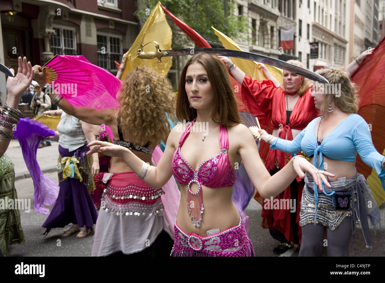 Anuual New York City Dance Parade along Broadway in New York City.  Belly dancers balance swords on their heads as they dance. Stock Photo