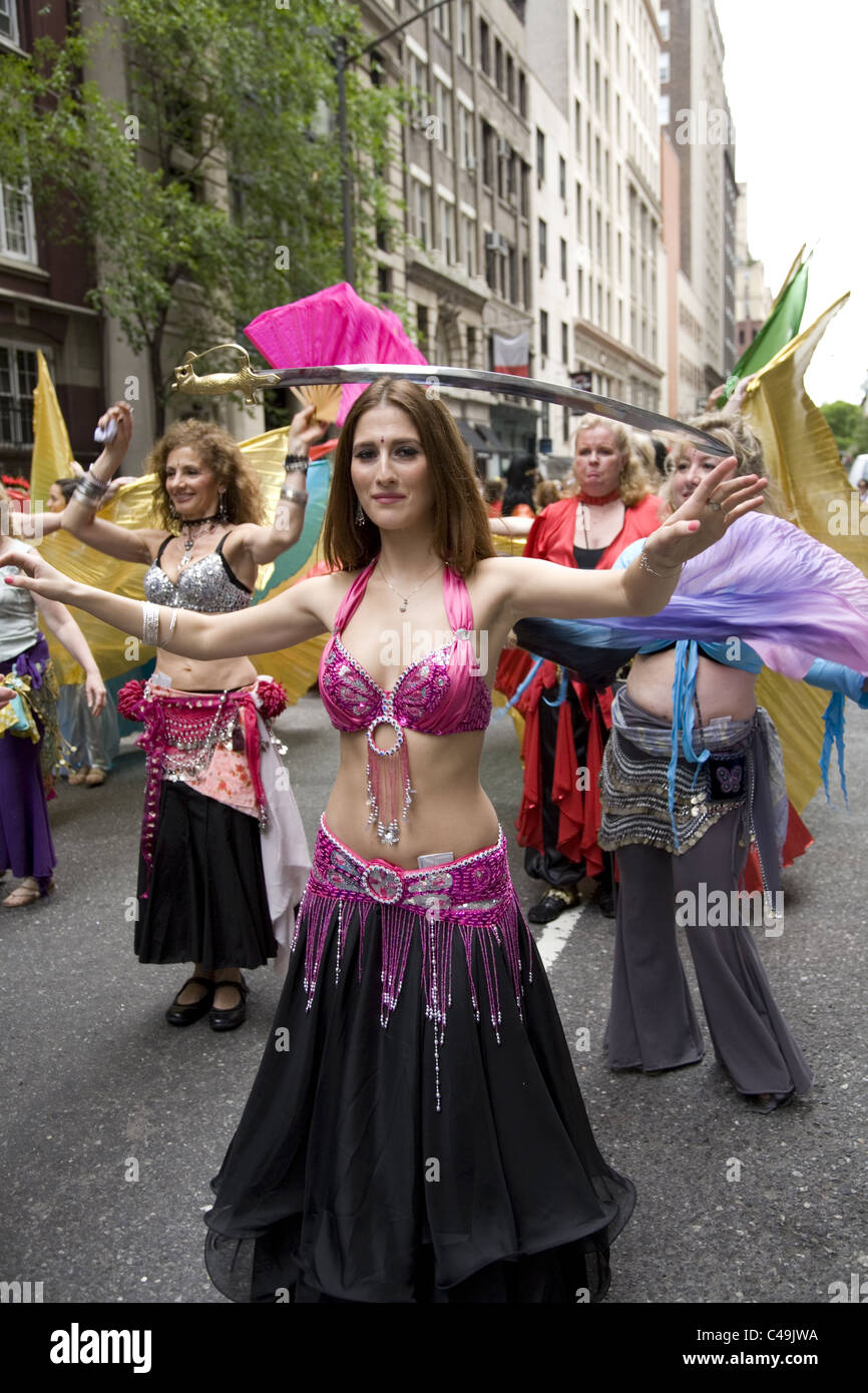 Anuual New York City Dance Parade along Broadway in New York City.  Belly dancers balance swords on their heads as they dance. Stock Photo
