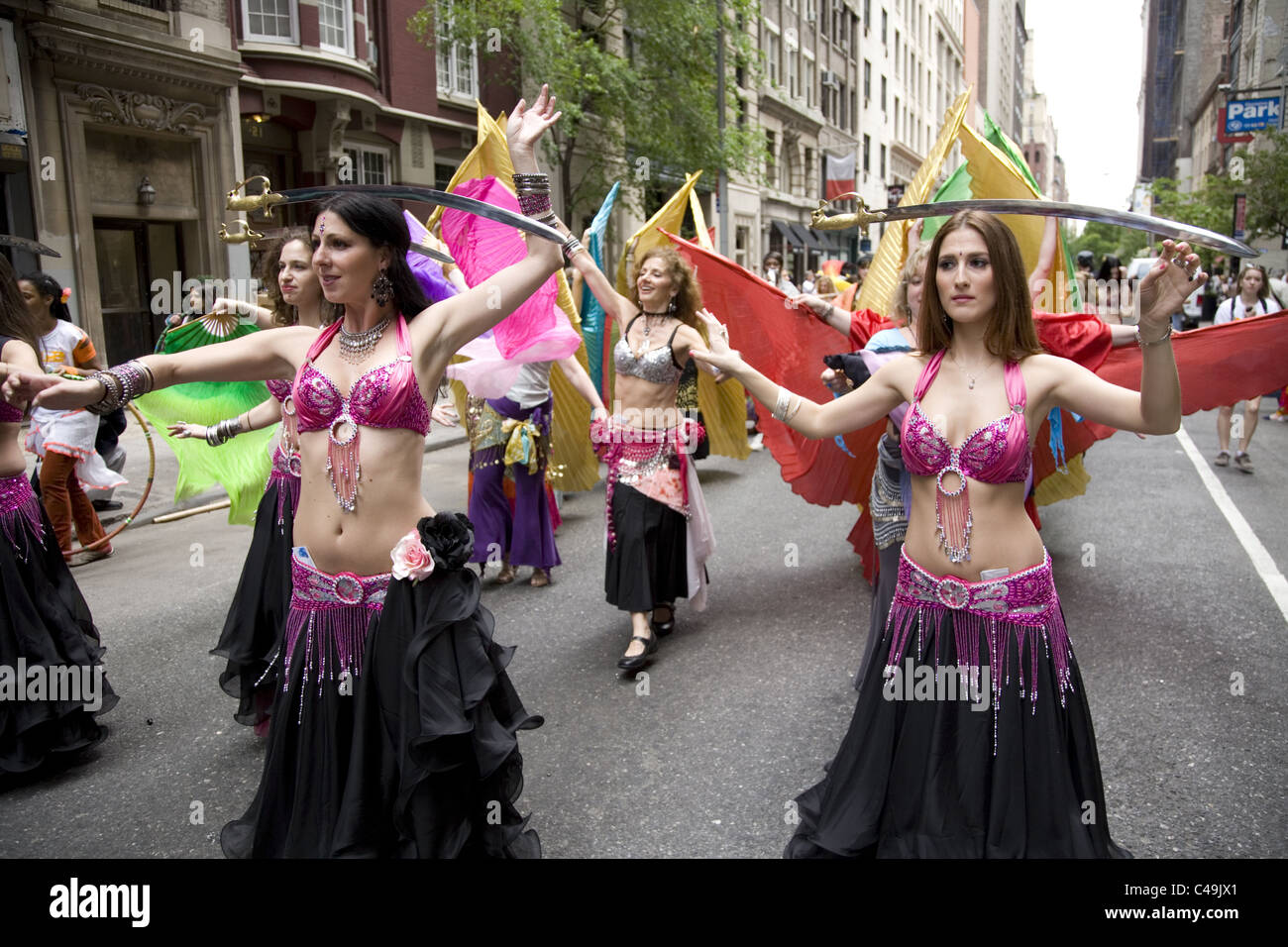 Anuual New York City Dance Parade along Broadway in New York City. Belly dancers balance swords on their heads as they dance. Stock Photo