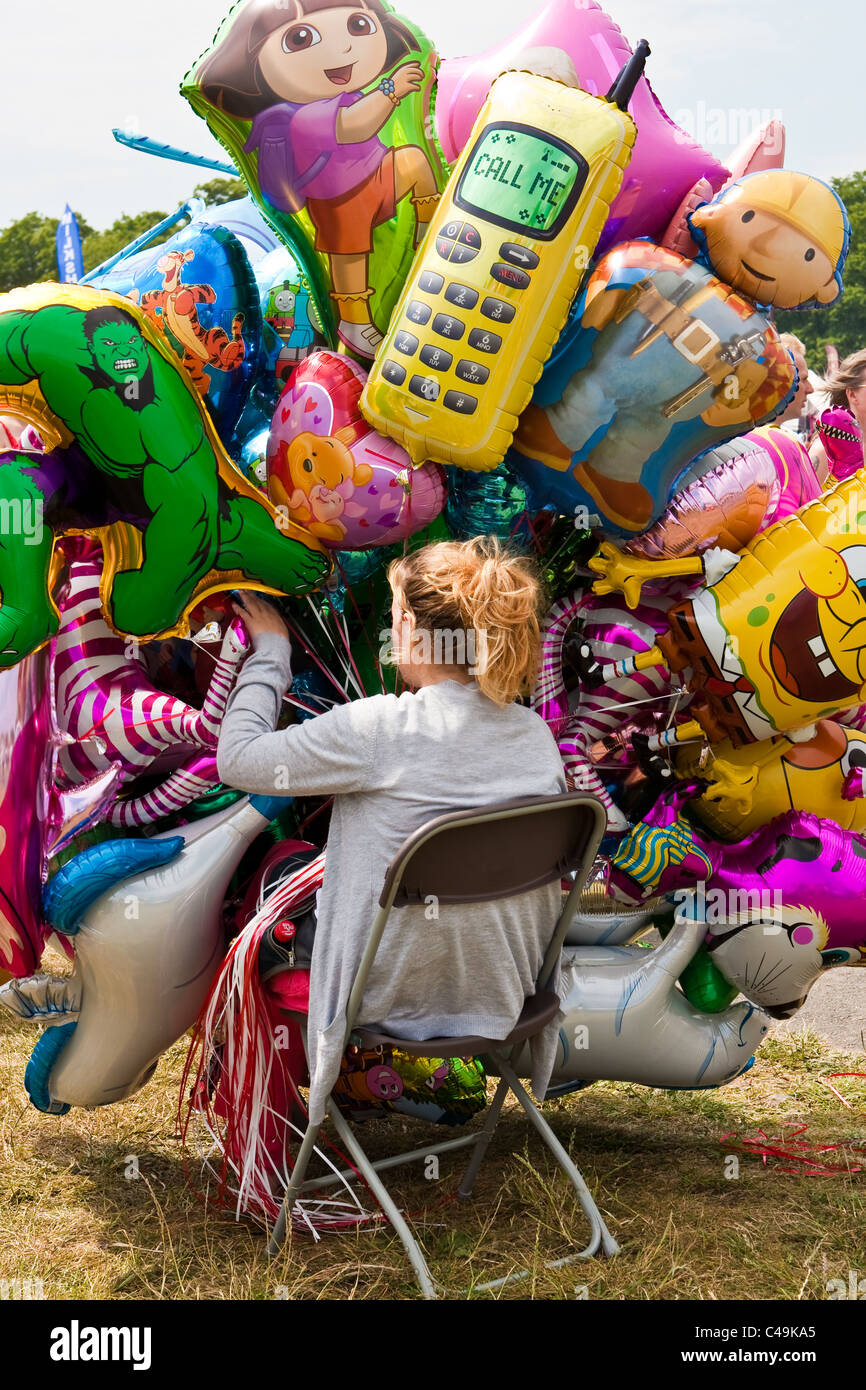 Young woman selling helium balloons at the Cambridge Strawberry Fair