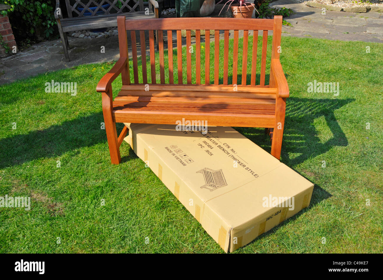 Imported assembled hardwood self assembly flat pack garden seat & empty cardboard packaging box which contained all the components England UK Stock Photo
