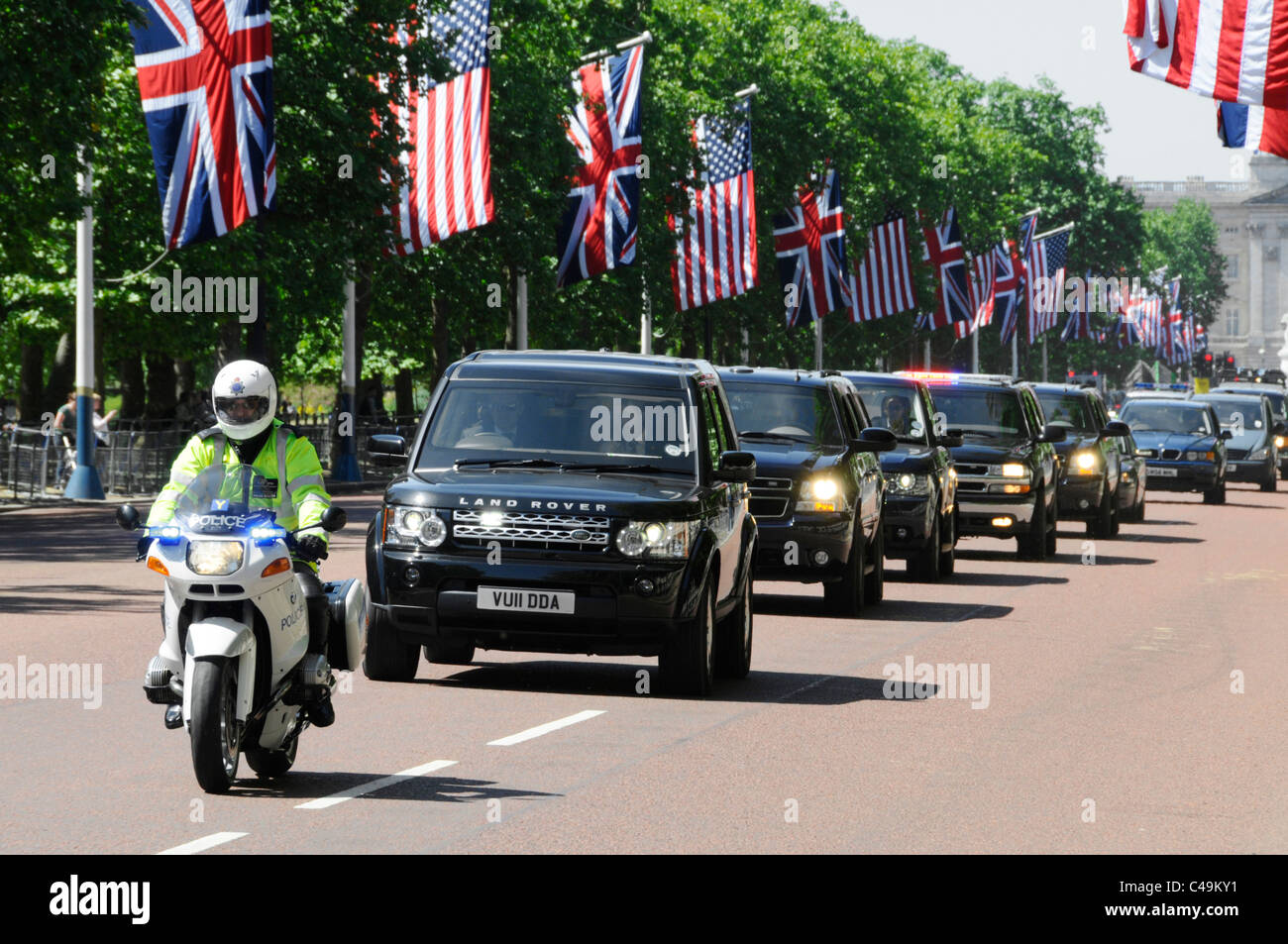 Motorbike Met police & motorcade of UK & USA security guard cars in The Mall London for President Obama state visit Union Jack & American flag England Stock Photo