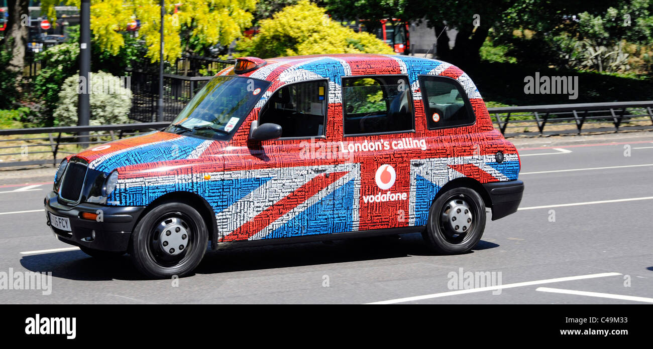 Close up view black Taxi cab temporary covered unusual Vodafone London Calling Union Jack flag & text tag word cloud advertising graphic England UK Stock Photo