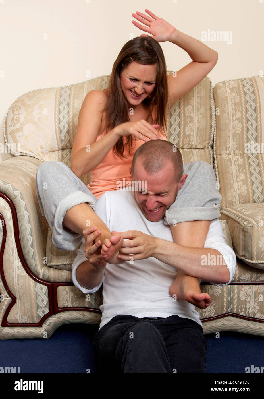 Man tickling woman's foot Stock Photo