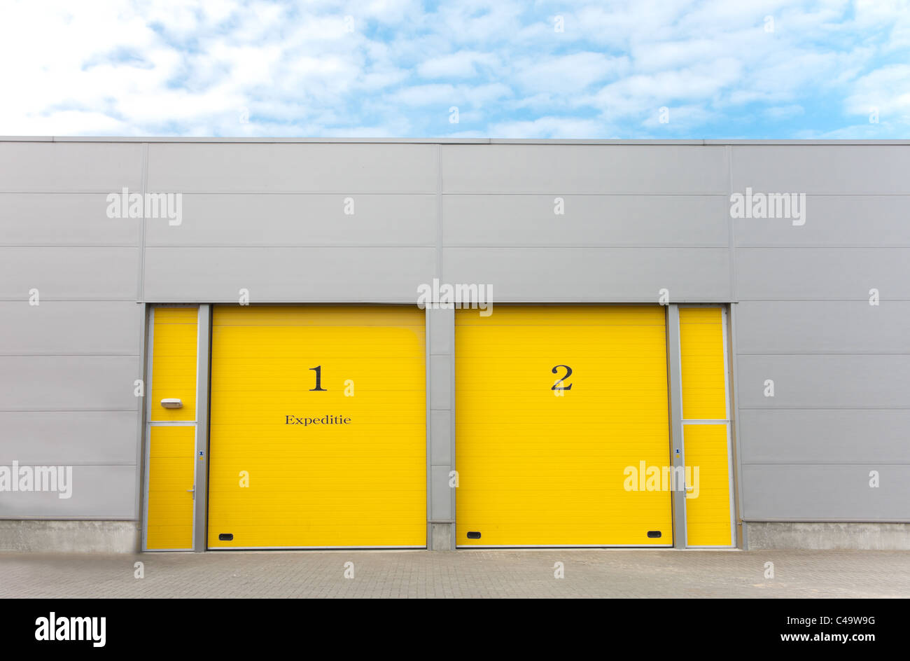 industrial warehouse with yellow roller doors Stock Photo - Alamy